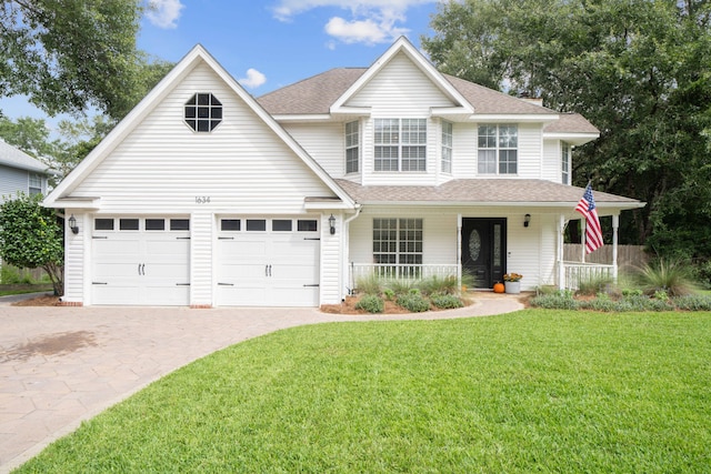 view of front of home with a garage, a front lawn, and covered porch