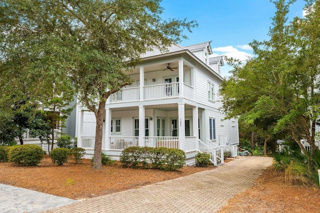 neoclassical home featuring a balcony and covered porch