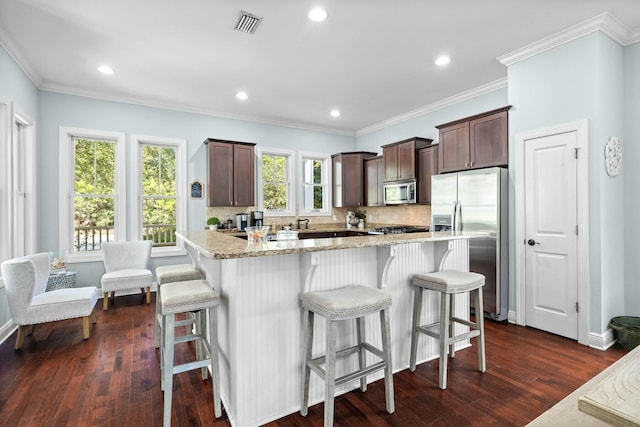 kitchen featuring decorative backsplash, appliances with stainless steel finishes, dark hardwood / wood-style floors, and a wealth of natural light