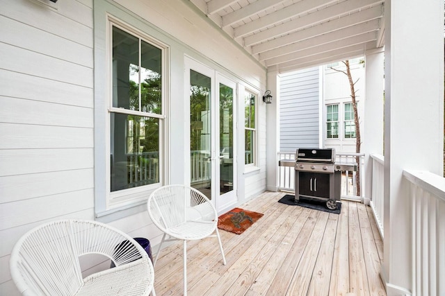 sunroom / solarium featuring beamed ceiling