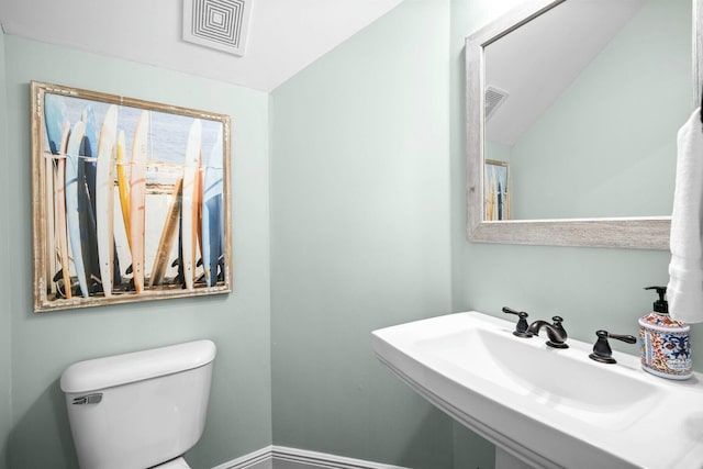 bathroom with sink, lofted ceiling, and toilet