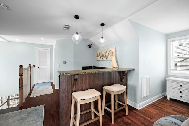 bar with dark hardwood / wood-style flooring, white cabinets, hanging light fixtures, and vaulted ceiling