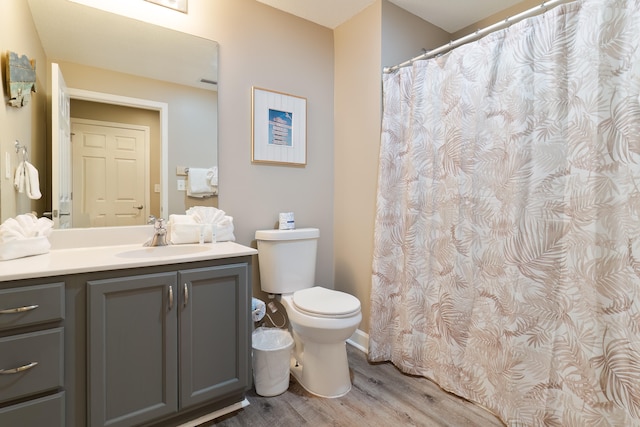 bathroom with curtained shower, hardwood / wood-style floors, vanity, and toilet