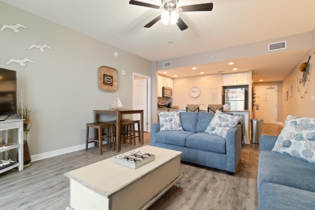 living room featuring ceiling fan and hardwood / wood-style flooring