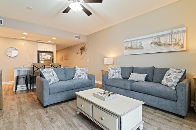 living room featuring light wood-type flooring and ceiling fan