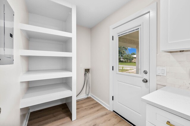 doorway featuring electric panel and light wood-type flooring