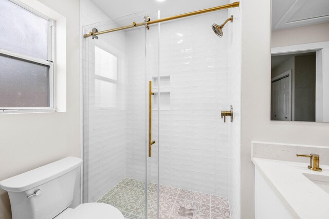 bathroom featuring a shower with door, vanity, and toilet