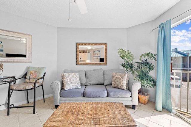 tiled living room featuring baseboards and ceiling fan