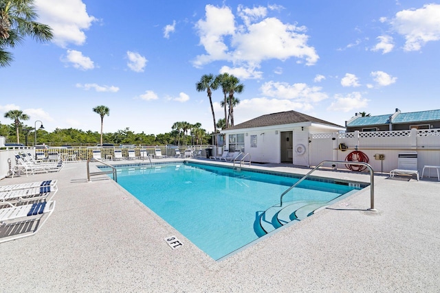 community pool featuring a patio and fence