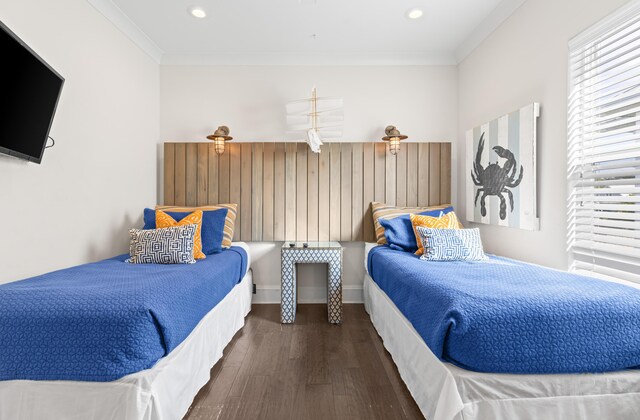 bedroom with ornamental molding and dark hardwood / wood-style floors