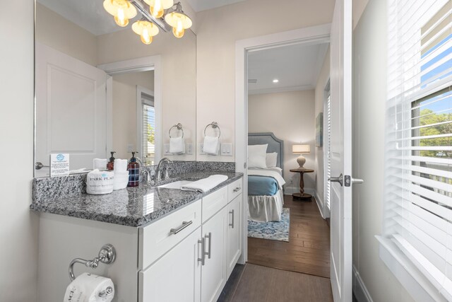 bathroom with wood-type flooring, a chandelier, and vanity