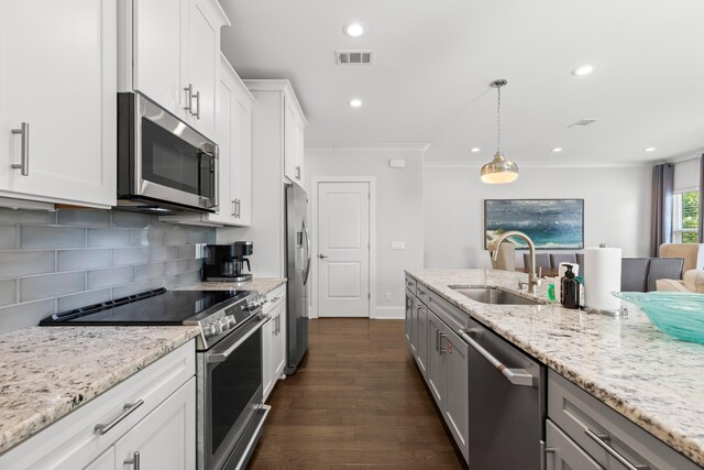 kitchen with white cabinets, sink, decorative light fixtures, dark wood-type flooring, and appliances with stainless steel finishes