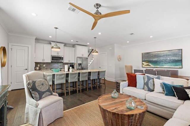 living room with ornamental molding, ceiling fan, sink, and dark hardwood / wood-style flooring