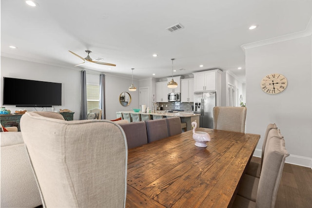 dining room featuring ornamental molding, ceiling fan, dark hardwood / wood-style floors, and sink