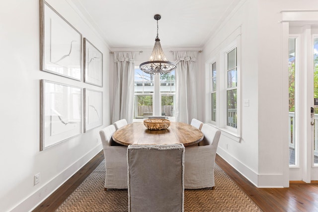 dining area with crown molding, a chandelier, and dark hardwood / wood-style floors