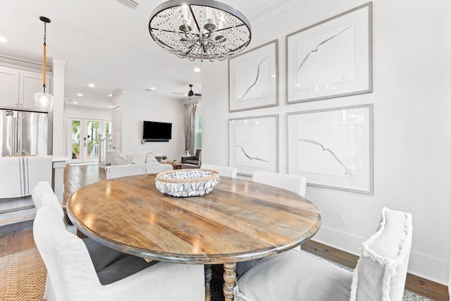 dining area with ceiling fan with notable chandelier and dark hardwood / wood-style flooring