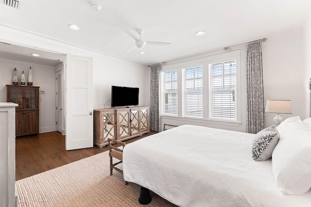 bedroom with ceiling fan, ornamental molding, and dark hardwood / wood-style floors