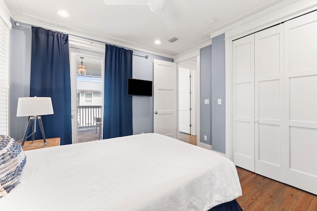 bedroom with crown molding, dark hardwood / wood-style floors, a closet, and ceiling fan