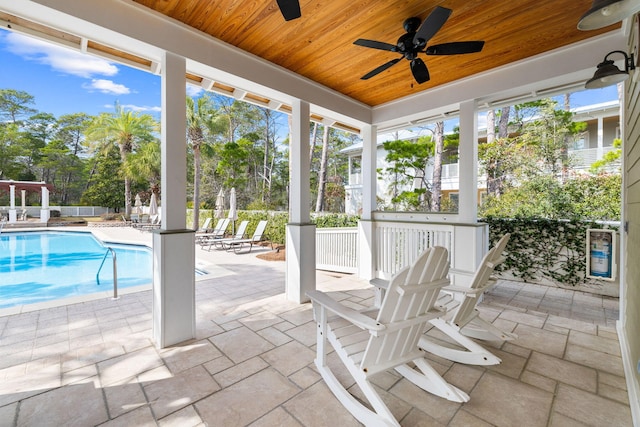 unfurnished sunroom with wood ceiling and ceiling fan