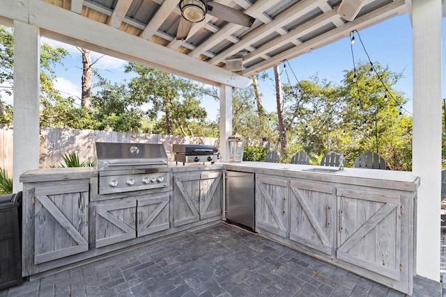 view of patio / terrace with area for grilling, ceiling fan, sink, and exterior kitchen