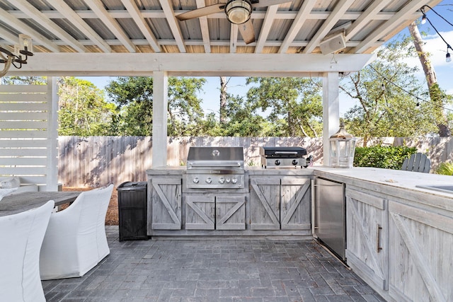 view of patio / terrace featuring exterior kitchen, area for grilling, and ceiling fan