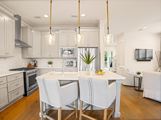 47 Trail Ln, Santa Rosa Beach, FL 32459 - kitchen featuring appliances with stainless steel finishes, wall chimney range hood, crown molding, light countertops, and a kitchen breakfast bar