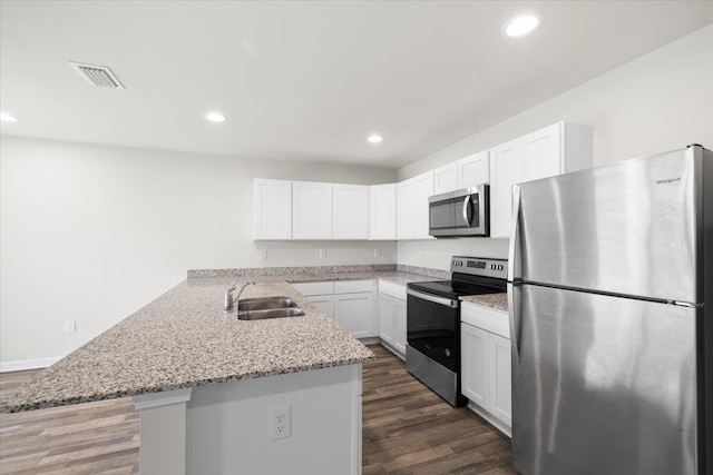 kitchen featuring sink, kitchen peninsula, white cabinetry, stainless steel appliances, and dark hardwood / wood-style floors