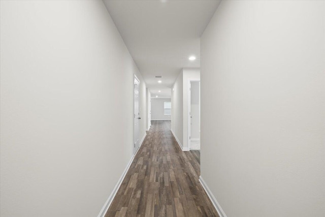 corridor with dark hardwood / wood-style flooring