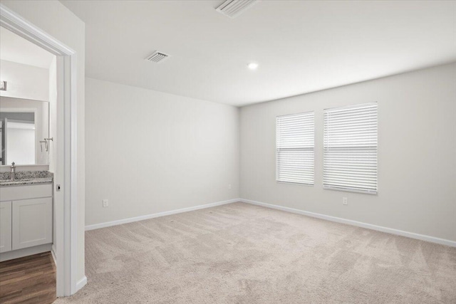 carpeted empty room featuring sink