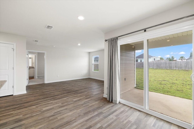 empty room with hardwood / wood-style floors and plenty of natural light