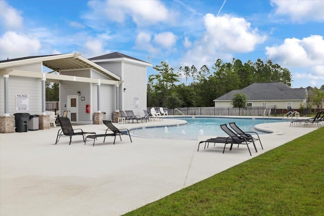 view of pool featuring a patio and a yard