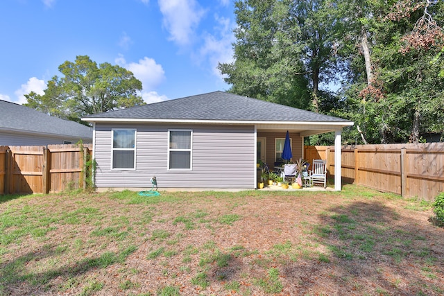 rear view of house featuring a lawn