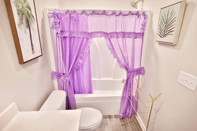 bathroom featuring wood-type flooring, shower / tub combo with curtain, and toilet