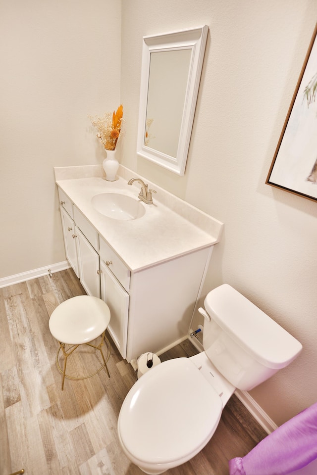 bathroom featuring wood-type flooring, vanity, and toilet