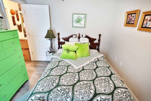 bedroom with hardwood / wood-style flooring and connected bathroom