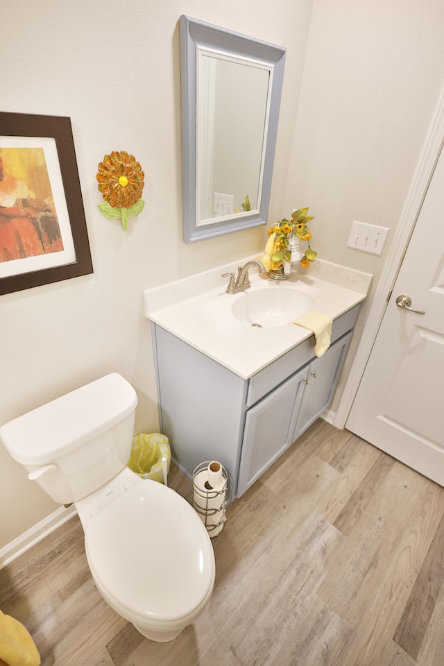 bathroom with vanity, toilet, and hardwood / wood-style flooring