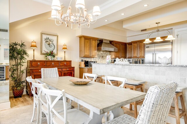 dining area with an inviting chandelier, light hardwood / wood-style flooring, beverage cooler, and ornamental molding