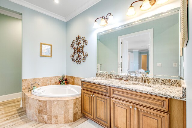 bathroom with vanity, hardwood / wood-style flooring, a relaxing tiled tub, and ornamental molding