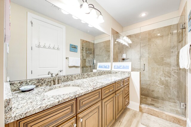 bathroom featuring vanity, hardwood / wood-style flooring, and an enclosed shower