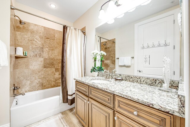 bathroom with hardwood / wood-style flooring, vanity, and shower / bath combo with shower curtain