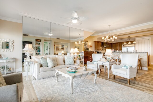 living room featuring ceiling fan with notable chandelier, crown molding, and light hardwood / wood-style flooring