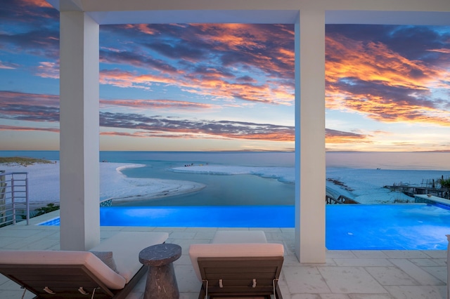 view of swimming pool with a view of the beach and a water view