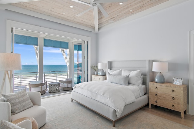 bedroom with wooden ceiling, a view of the beach, a water view, wood finished floors, and access to exterior