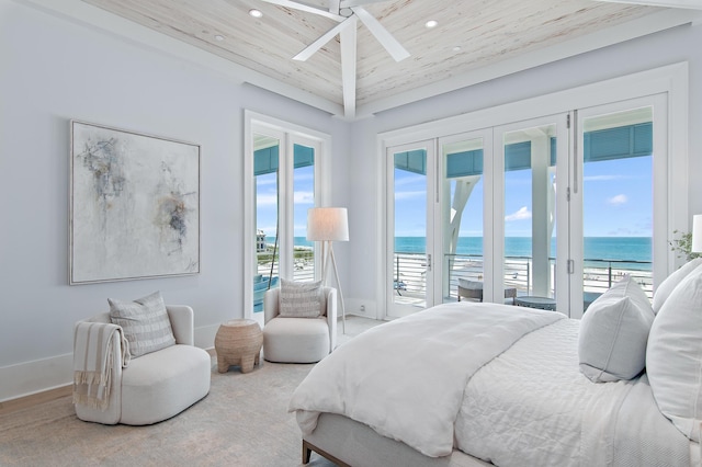 bedroom with access to exterior, a water view, baseboards, and multiple windows