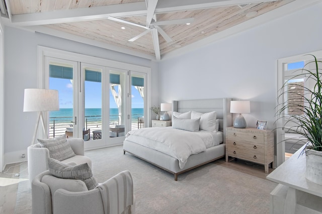 bedroom featuring beam ceiling, a water view, wooden ceiling, and access to exterior