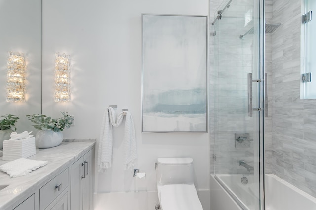 full bath with toilet, combined bath / shower with glass door, and vanity