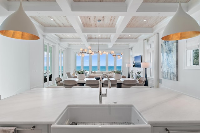 interior space with pendant lighting, light countertops, a sink, and open floor plan