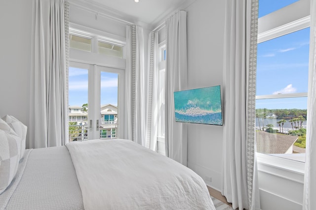 bedroom with access to outside, french doors, and a water view