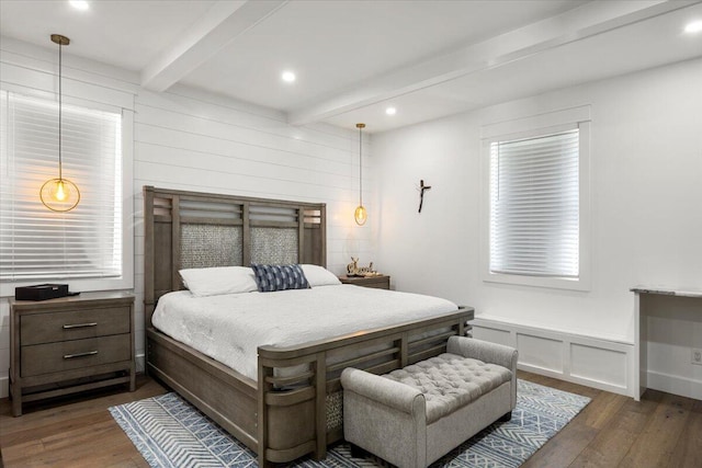 bedroom featuring multiple windows, beam ceiling, and dark hardwood / wood-style floors