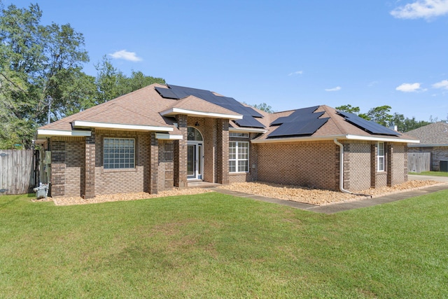 ranch-style home featuring solar panels and a front yard